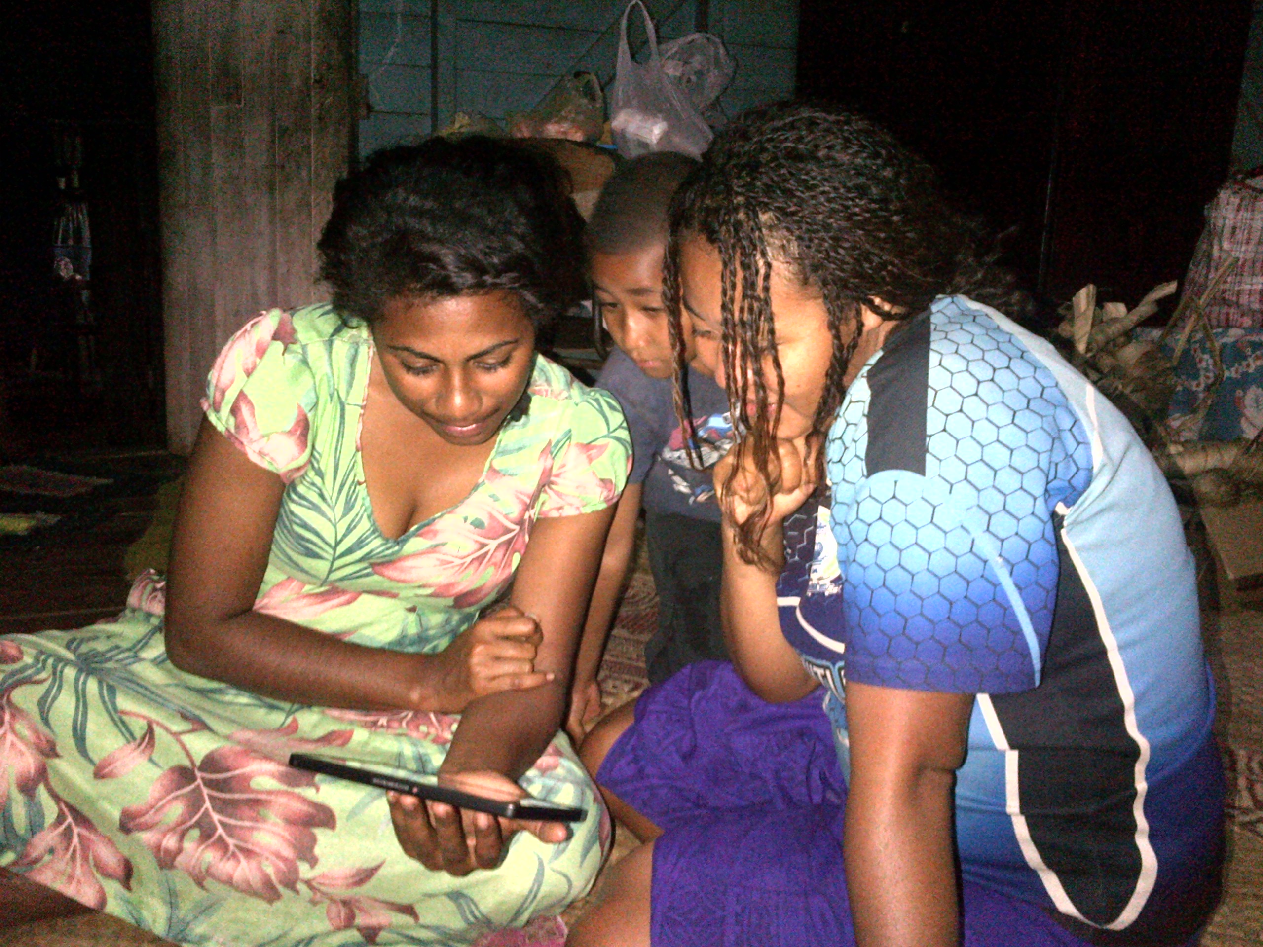 Young Fijian women look at my photos of Canada.